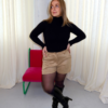short beige en suédine avec bouton et passants pour ceinture porté avec col roulé noir et bottes