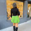 Visuel site - 72 Dos Jupe plissée verte stylée avec col roulé noir et bottes noires